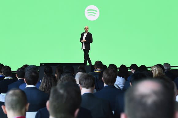 Daniel Ek on stage with a green background and the Spotify logo