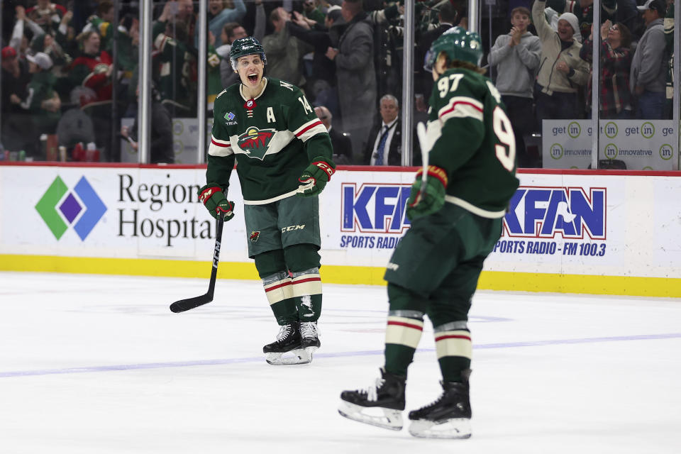 Minnesota Wild center Joel Eriksson Ek, left, celebrates left wing Kirill Kaprizov's (97) hat-trick goal against the Vancouver Canucks during the third period of an NHL hockey game, Monday, Feb. 19, 2024, in St. Paul, Minn. (AP Photo/Matt Krohn)