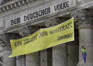 Activists of Greenpeace extendet the inscription 'Dem deutschen Volke' (To the German People) on top of the entrance of the Reichstag building, home of the German parliament Bundestag, with the slogan 'Eine Zukunft Ohne Kohlekraft' (a future without coal power) in Berlin, Germany, Friday, July 3, 2020. (AP Photo/Michael Sohn)