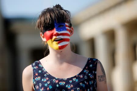 A campaigner with a American and German flag painted on her face stands in front of the Brandenburg Gate to urge Americans living abroad to register and vote in Berlin, Germany, September 23, 2016. REUTERS/Axel Schmidt