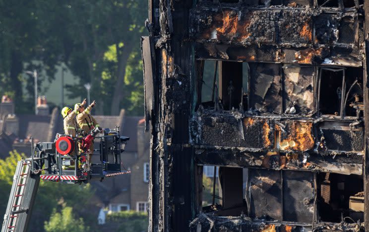 Firefighters survey the damage to the fire-gutted Grenfell Tower in London, (Photo: Rick Findler/ PA via AP)