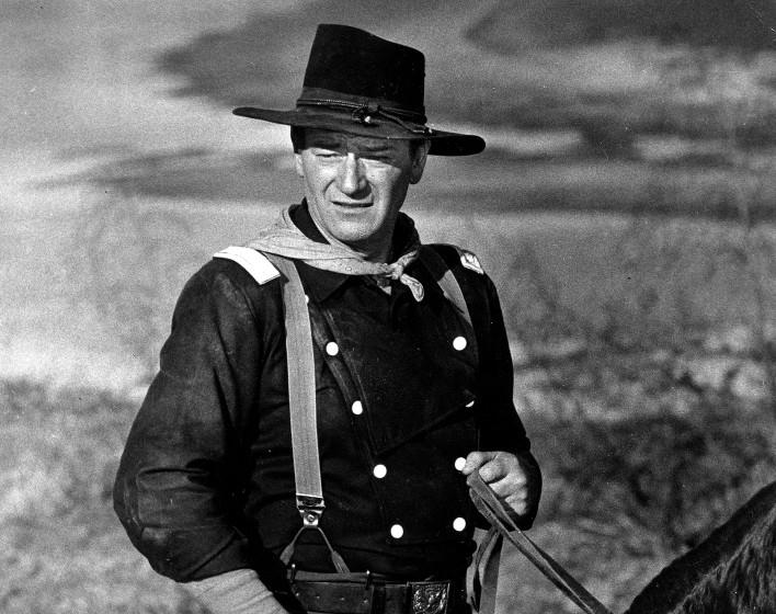 FILE - In this undated photo, John Wayne appears during the filming of "The Horse Soldiers." In the latest move to change place names in light of U.S. racial history, leaders of Orange County's Democratic Party are pushing to drop film legend Wayne's name, statue and other likenesses from the county's airport because of his racist and bigoted comments. (AP Photo, File)