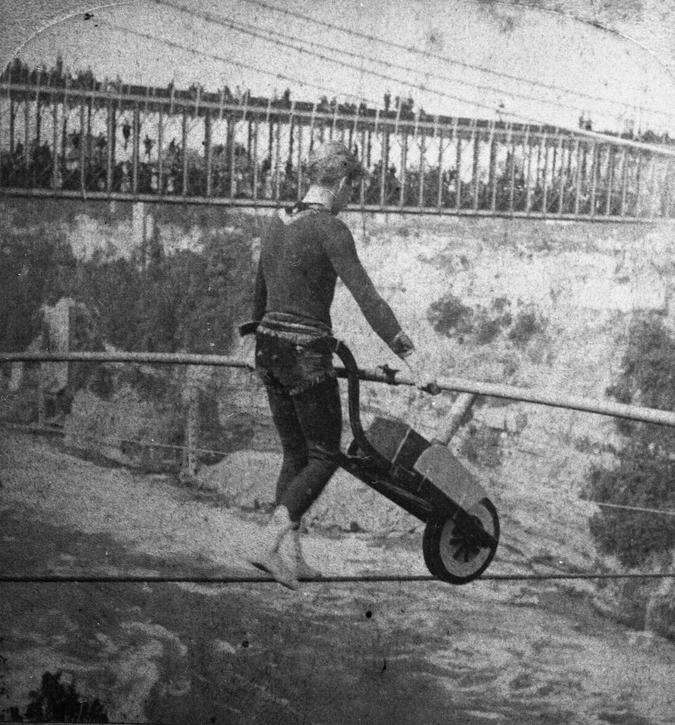 Jean Francois Gravelet tightrope walks across the Niagara River Gorge pushing a wheelbarrow in 1859.