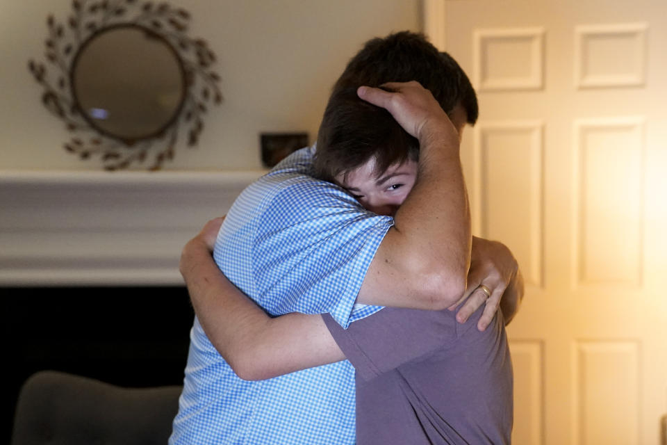Dan Bradford, left, embraces his son Callum, at their home, Thursday, Sept. 14, 2023, in Chapel Hill, N.C. Bradford, a transgender teen from Chapel Hill needed mental health care after overdosing on prescription drugs. He was about to be transferred to another hospital due to a significant bed shortage. A North Carolina hospital network is referring transgender psychiatric patients to treatment facilities that do not align with their gender identities. Though UNC Hospitals policy discourages the practice, administrators say a massive bed shortage is forcing them to make tough decisions. (AP Photo/Erik Verduzco)