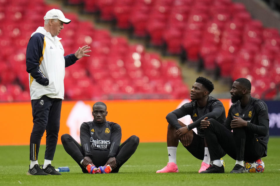 Real Madrid's head coach Carlo Ancelotti, from left, speaks to Real Madrid's Ferland Mendy, Real Madrid's Aurelien Tchouameni and Real Madrid's Antonio Rudiger during a training session ahead of the Champions League final soccer match between Borussia Dortmund and Real Madrid at Wembley Stadium in London , Friday, May 31, 2024.(AP Photo/Kirsty Wigglesworth)