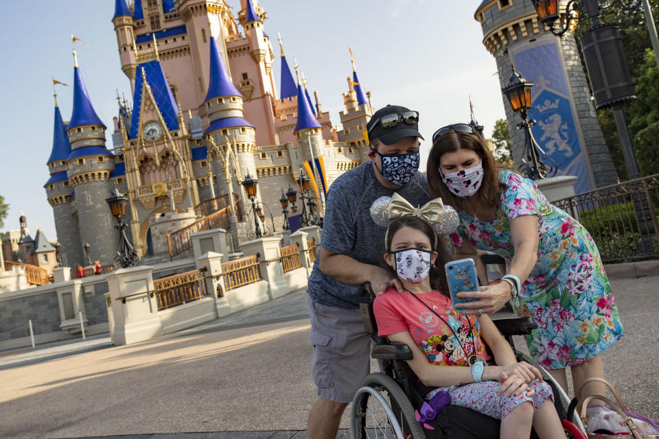 LAKE BUENA VISTA, FL - JULY 11:  In this handout photo provided by Walt Disney World Resort, guests take a selfie at Magic Kingdom Park at Walt Disney World Resort on July 11, 2020 in Lake Buena Vista, Florida. July 11, 2020 is the first day of the phased reopening. (Photo by Matt Stroshane/Walt Disney World Resort via Getty Images)