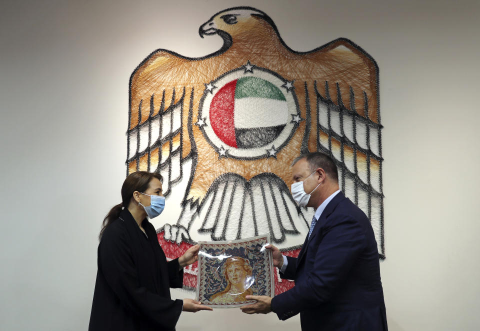 UAE Minister of State for Food and Water Security Mariam al-Muhairi, left, receives a gift from Erel Margalit, founder and chairman of Jerusalem Venture Partners, JVP, at the headquarter of the Government Accelerators in Dubai, United Arab Emirates, Tuesday, Oct. 27, 2020. Another plane full of Israeli business people excited about their newfound access to the UAE has touched down in Dubai this week. It's the latest whirlwind trip seeking to cash in on a U.S.-brokered deal to normalize relations between the countries. (AP Photo/Kamran Jebreili)