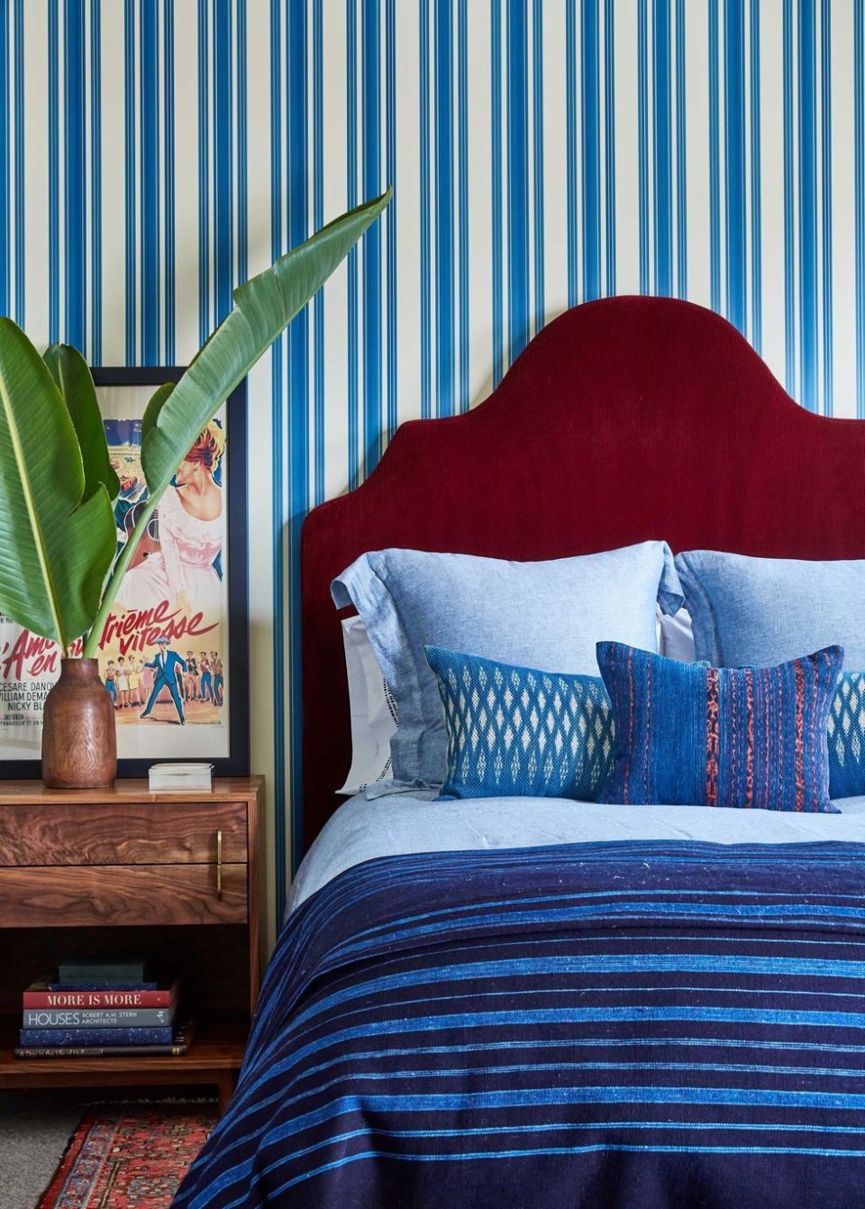 a bed with pillows and linens in indigo hues