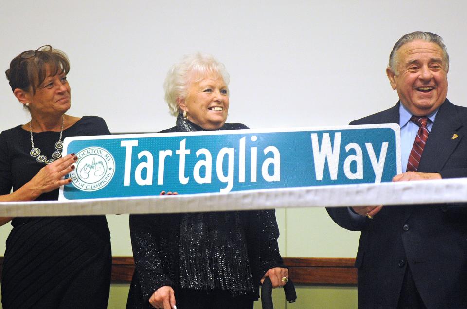 Charlie Tartaglia accepts a street sign, which will be hung to rename the current Day Avenue in Brockton, with his daughter Dee-Dee Kashgagian, left, and his wife, Penny Tartaglia, during the Ring of Champions dinner at The Shaw's Center in Brockton on Thursday, Dec. 5, 2013.