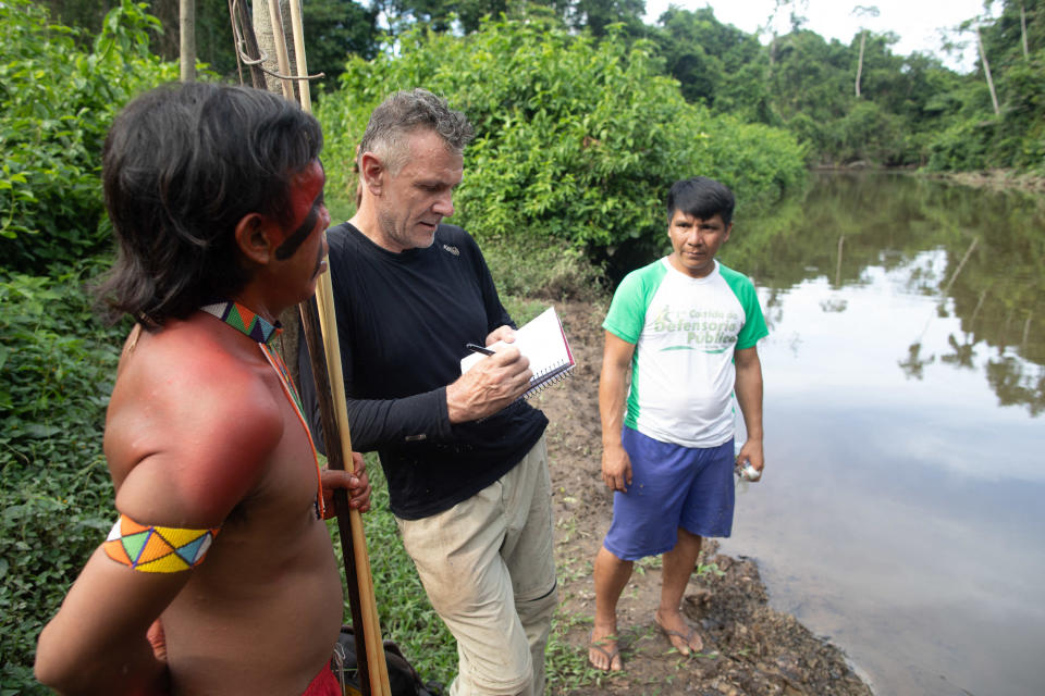 Veteran British foreign correspondent Dom Phillips talks to two indigenous men in Aldeia Maloca Papia, Roraima State, Brazil, November 16, 2019. / Credit: JOAO LAET/AFP/Getty