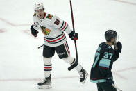 Chicago Blackhawks left wing Brandon Hagel, left, reacts next to Seattle Kraken center Yanni Gourde (37) after scoring a goal during the second period of an NHL hockey game, Monday, Jan. 17, 2022, in Seattle. (AP Photo/Ted S. Warren)