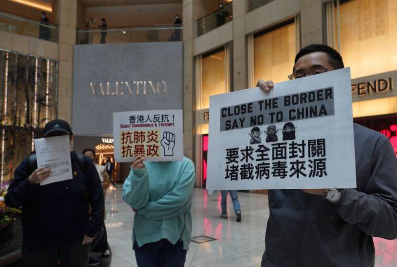 武漢肺炎疫情肆虐，每日有大量中國旅客進入的香港至今未能全面封關，多位香港民眾手持標語抗議。（美聯社）