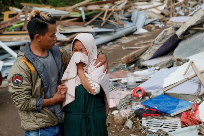 A woman reacts after watching her destroyed home following Monday's earthquake that hit Cianjur