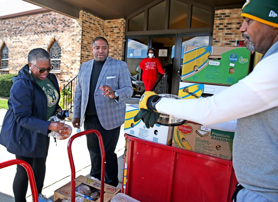 Sharon Spencer, left, Rev. Christopher Boston, pastor of Lamb of God Missionary Baptist Church, center and William Redd, right, wait for people to arrive for the weekly Know Hunger No More, food distribution on Wednesday, Sept. 28, 2022 at the church located at 8415 W. Bradley Road, Milwaukee. The church has taken it upon themselves to buy certain items that they cannot get from Feeding America.