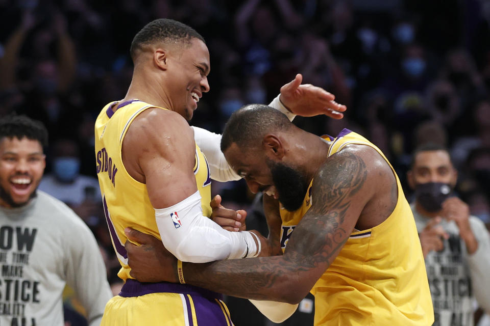 Los Angeles Lakers guard Russell Westbrook, left, is congratulated by forward LeBron James after scoring against the Utah Jazz during the second half of an NBA basketball game in Los Angeles, Monday, Jan. 17, 2022. The Lakers won 101-95. (AP Photo/Ringo H.W. Chiu)