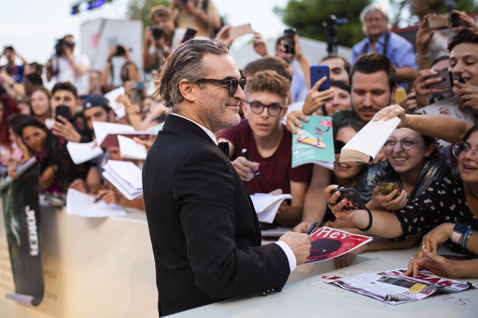 Joaquin Phoenix signs autographs upon arrival at the premiere of the film 'Joker' at the 2019 edition of the Venice Film Festival. (Photo by Arthur Mola/Invision/AP)