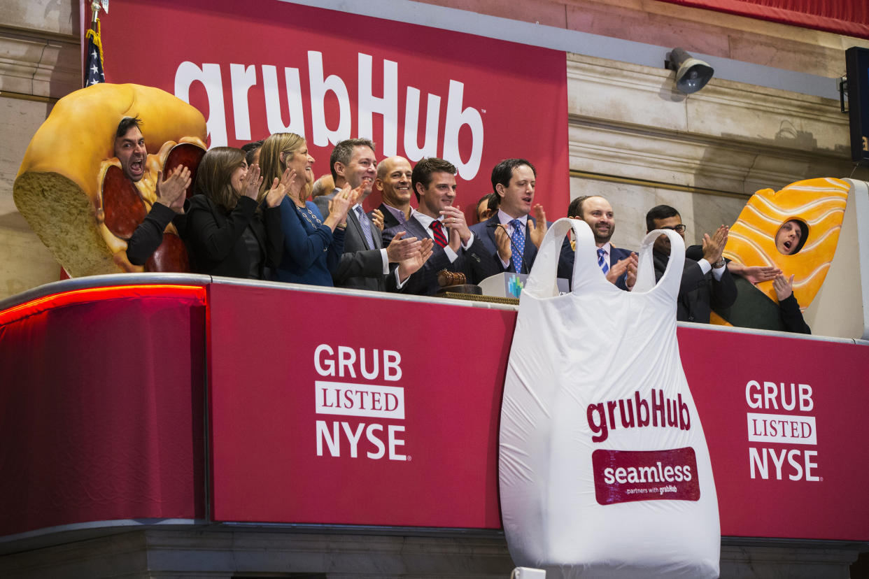 Grubhub CEO Matt Maloney (C) applauds after ringing the opening bell before the company's IPO on the floor of the New York Stock Exchange in New York April 4, 2014. Shares of GrubHub Inc, the biggest U.S. online food-delivery service, rose as much as 57 percent in its market debut as investors scrambled for a piece of the fast-growing consumer internet company. REUTERS/Lucas Jackson (UNITED STATES - Tags: BUSINESS FOOD)