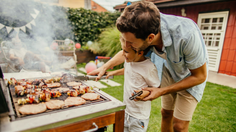 man and child grilling food