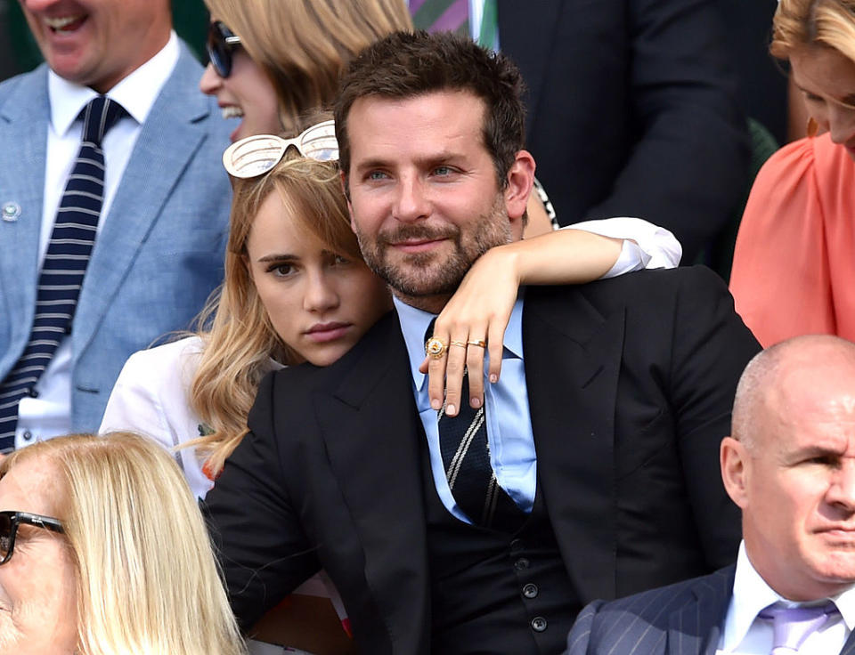 Suki and Bradley seated closely, with expressions of focus, at an outdoor event