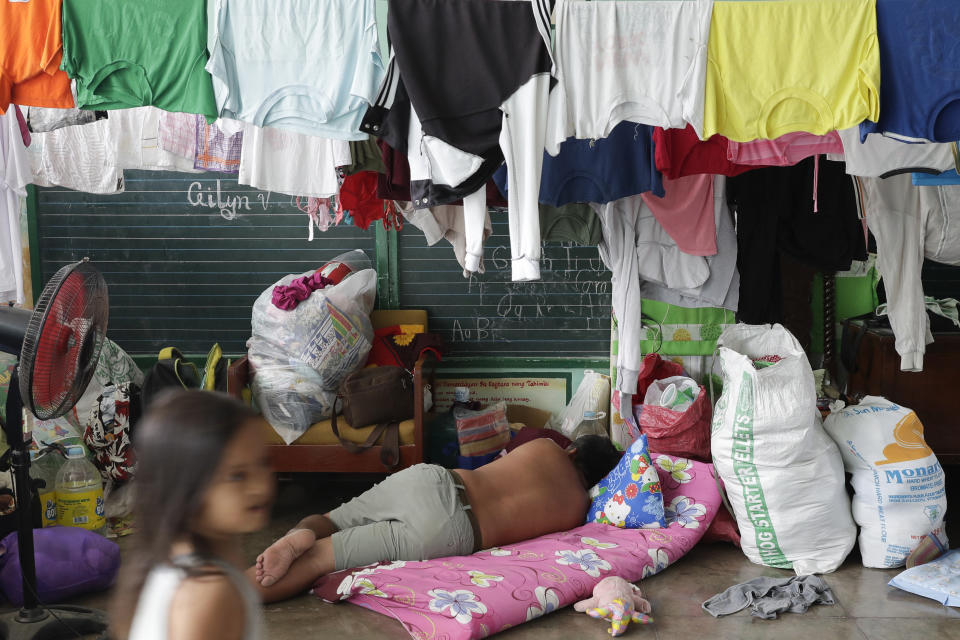 Un hombre duerme en un centro temporal de evacuación durante la erupción del volcán Taal en Santa Teresita, en la provincia de Batangas, sur de Filipinas, el jueves 16 de enero de 2020. (AP Foto/Aaron Favila)