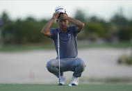 Collin Morikawa of the United States, adjusts his cap as he prepares a putter shot on the 17th green on day three of the Hero World Challenge PGA Tour at the Albany Golf Club, in New Providence, Bahamas, Saturday, Dec. 4, 2021.(AP Photo/Fernando Llano)