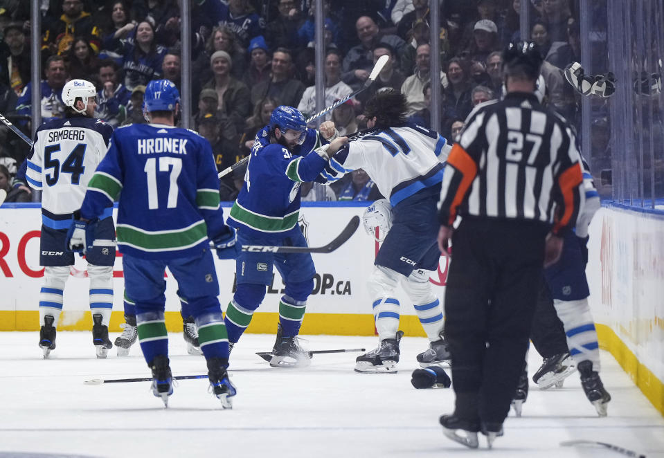 Vancouver Canucks' Phillip Di Giuseppe and Winnipeg Jets' Adam Lowry, right, fight during the second period of an NHL hockey game Saturday, Feb. 17, 2024, in Vancouver, British Columbia. (Darryl Dyck/The Canadian Press via AP)