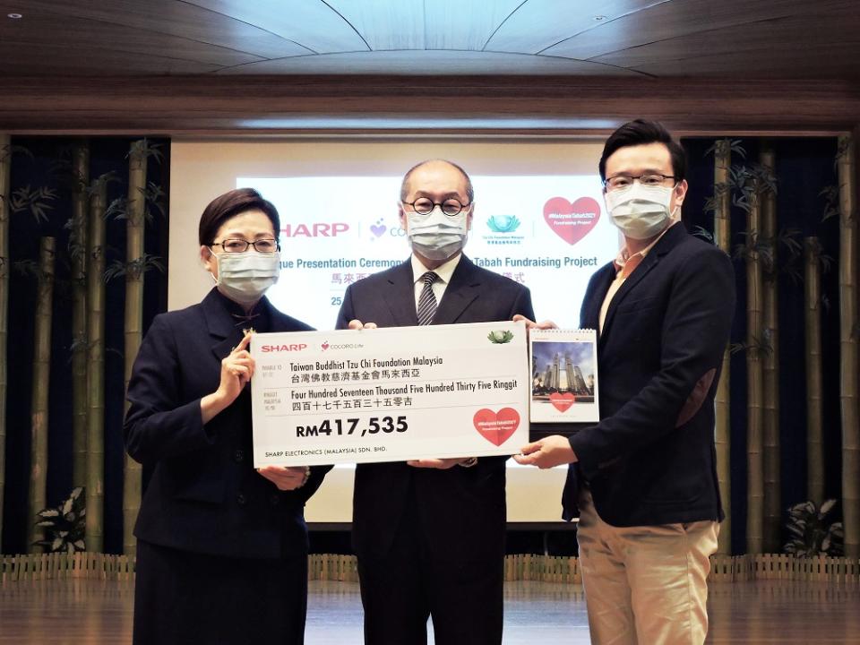 Chien (left) receiving the mock cheque from Ting (right) at the cheque presentation ceremony as Liu looks on. ― Picture courtesy of Sharp Malaysia