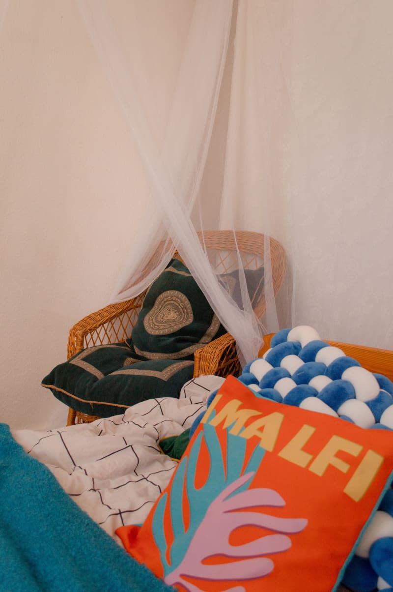 Decorative pillows on a wicker chair and bed.