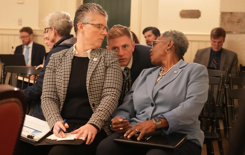 Ohio Department of Youth Services Director Amy Ast (left) listens to communications director Aaron Mulvey and assistant director Ginine Trim in the moments before Ast began to answer questions from lawmakers on the Correctional Institution Inspection Committee.
