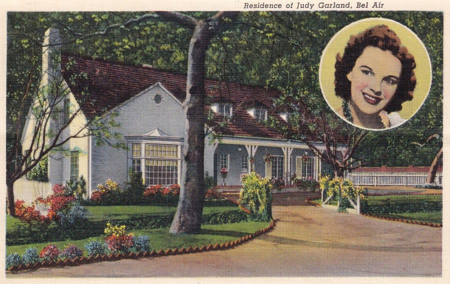 <em>Vintage souvenir postcard published ca 1938 from the Movie Star Homes series, depicting mansions and grand beach estates of Hollywood celebrities in Los Angeles, California, here a view of the Bel Air cottage of actress Judy Garland, paired with a small round portrait of the actress (Photo by Nextrecord Archives / Getty Images).</em>