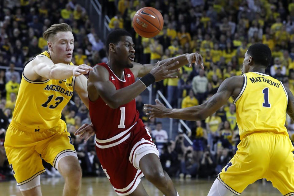 Michigan guard Charles Matthews, right, knocks the ball away from Indiana guard Aljami Durham, center, as Michigan's Ignas Brazdeikis (13) defends in the first half of an NCAA college basketball game in Ann Arbor, Mich., Sunday, Jan. 6, 2019. (AP Photo/Paul Sancya)