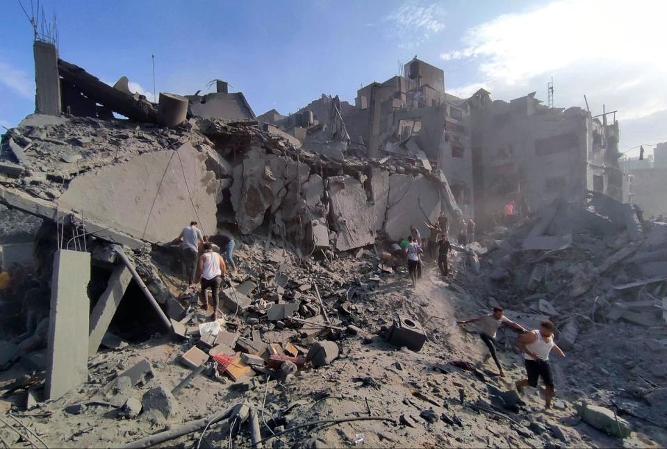 Palestinians looking for survivors in a crater following a stike on a refugee camp in Jabalia. (AP)