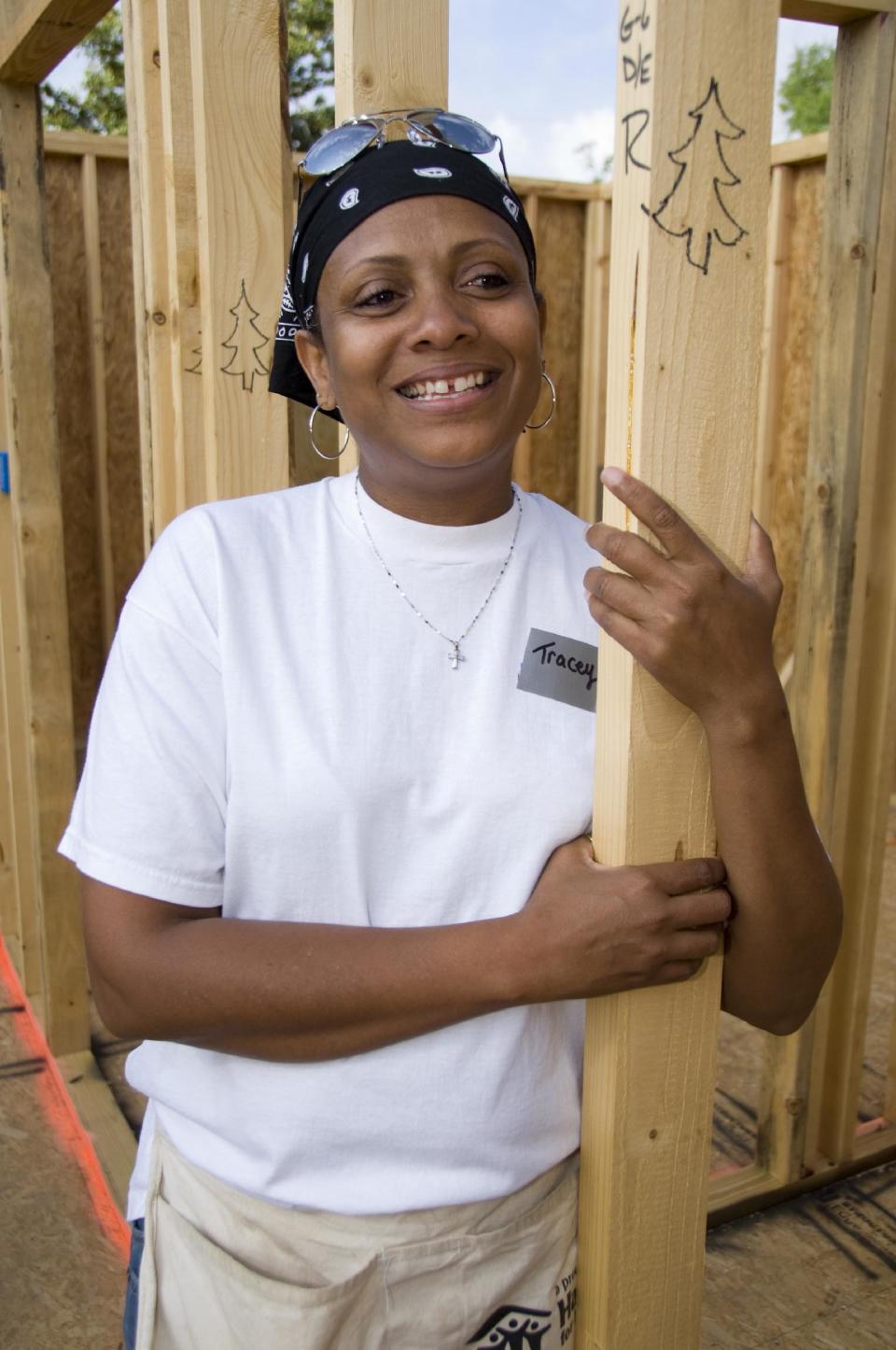 This April 2008 photo provided by Habitat for Humanity International shows Tracey Davison during the construction of her new home in Pascagoula, Miss. The boards with trees drawn on them came from the Rockefeller Center Christmas tree, which was milled for lumber in January 2008. This year will be the seventh year that the Rock Center tree is going to be donated to Habitat for Humanity to be used in building a new home. (AP Photo/Habitat for Humanity Internationa, Ezra Millstein)