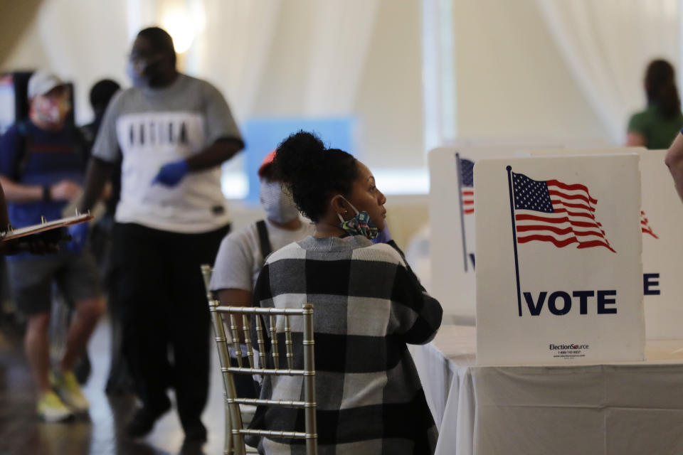 In this June 9, 2020 file photo, people wait to vote in the Georgia's primary election at Park Tavern in Atlanta. Twice delayed because of the coronavirus pandemic, Georgia’s primary earlier this year became a poster child for election dysfunction. Election officials say they are making sweeping changes to try to avoid a repeat in November, as Georgia emerges as a potential presidential battleground, turnout is expected to set records and the coronavirus continues to rage. (AP Photo/Brynn Anderson)