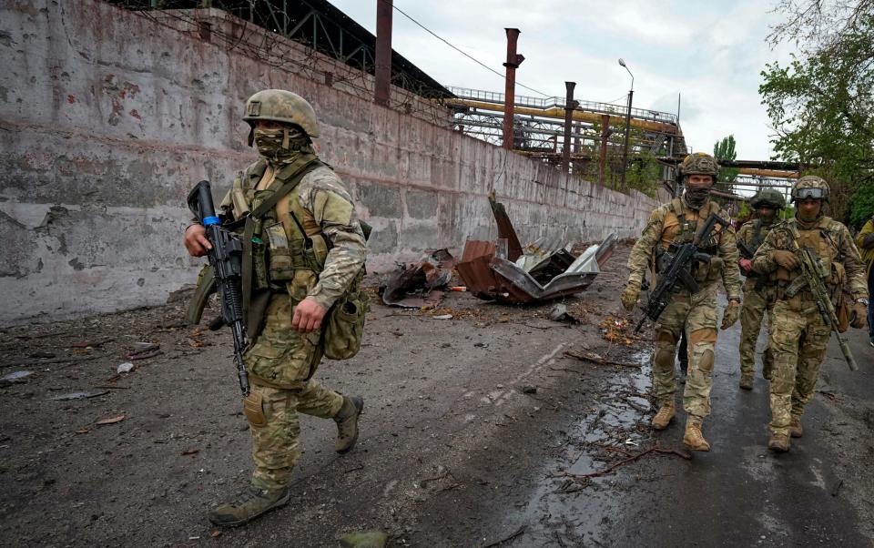 Russian soldiers patrol in Mariupol - AP Photo