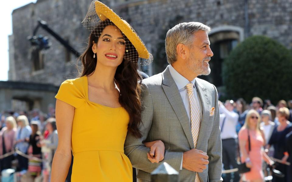 Amal Clooney wearing a hat made by milliner Stephen Jones and George Clooney - Gareth Fuller/ PA Wire