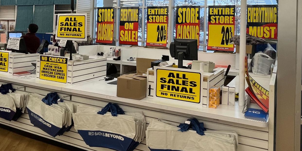 Store closing signs at a checkout counter of a Bed Bath and Beyond.