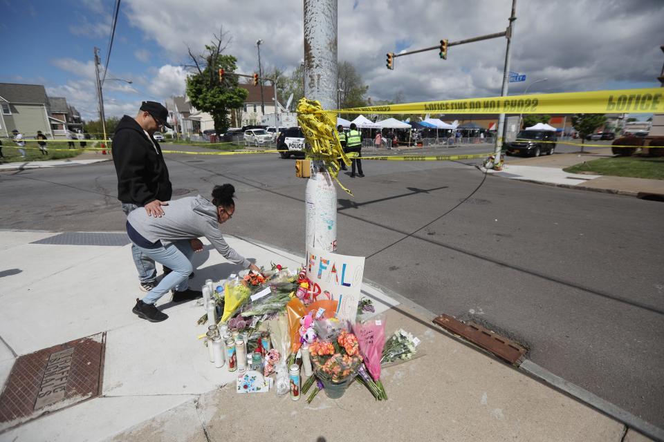 Violetta Walker and her boyfriend, Luis Amador, bring flowers to a memorial outside the Tops Friendly Market in Buffalo, N.Y.