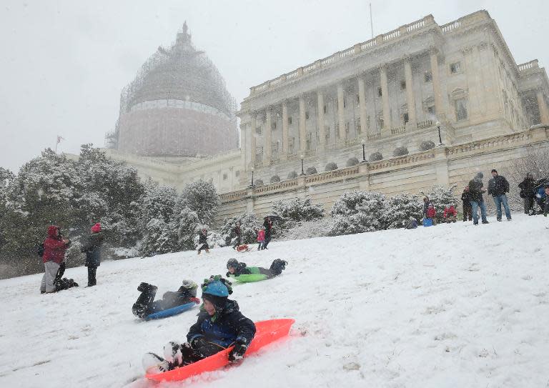 Children ride sleds down a hill on the West Lawn of the US Capitol on March 5, 2015 in Washington, DC