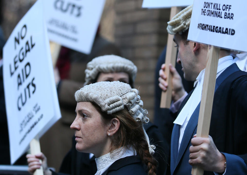 Lawyer Alice Jarratt takes part in a protest outside Southwark Crown Court during a demonstration against cuts to legal aid funding, in London, Monday, Jan. 6, 2014. Hundreds of British lawyers, many dressed in traditional wigs and gowns, have swapped courtrooms for picket lines to protest planned cuts to legal-aid funding. Hearings were disrupted Monday at courts including London’s famous Old Bailey as barristers staged their first-ever national walkout. The British government, which has slashed spending in the name of deficit reduction, plans to cut lawyers’ fees in a bid to reduce the legal aid budget by 220 million pounds ($360 million) by 2019. (AP Photo/Alastair Grant)