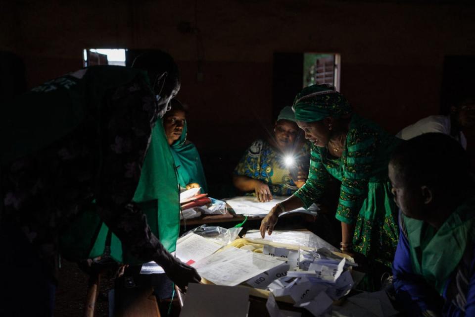 Election officials count the ballots in Mali’s referendum in Bamako on June 18, 2023, using the light from their cellphones. Mali often has electricity curtailment of up to eight hours a day (AFP via Getty Images)