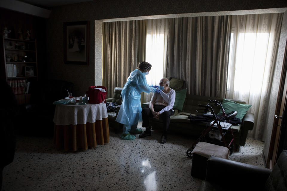 Nurse Pilar Rodríguez administers the COVID-19 vaccine to Rafael Capo Frau, 92, at his home in the town of Sa Pobla on the Spanish Balearic Island of Mallorca, Spain, Friday, April 30, 2021. Over a million Spaniards are considered by social services to be in need of help to feed and care for themselves. Some of these people are homebound and cannot respond to calls to go to vaccination points when their turn comes up. (AP Photo/Francisco Ubilla)