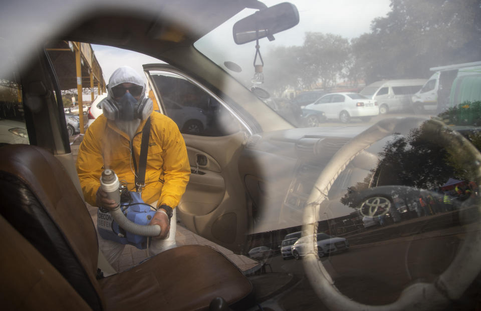A man wearing personnel protection equipment, disinfects a taxi during a procedure to help prevent the spread of the coronavirus at Tembisa township in Johannesburg, South Africa, May 19, 2020. (AP Photo/Themba Hadebe)