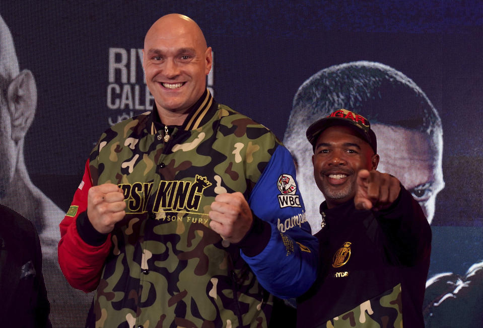 British professional boxer Tyson Fury, left, and trainer SugarHill Steward gesture during a news conference at the The Mazuma Mobile Stadium, Morecambe, England, Wednesday, April 10, 2024. Tyson Fury says size will count for everything in his fight with Oleksandr Usyk to crown the first undisputed heavyweight champion since 2000. (Owen Humphreys/PA via AP)