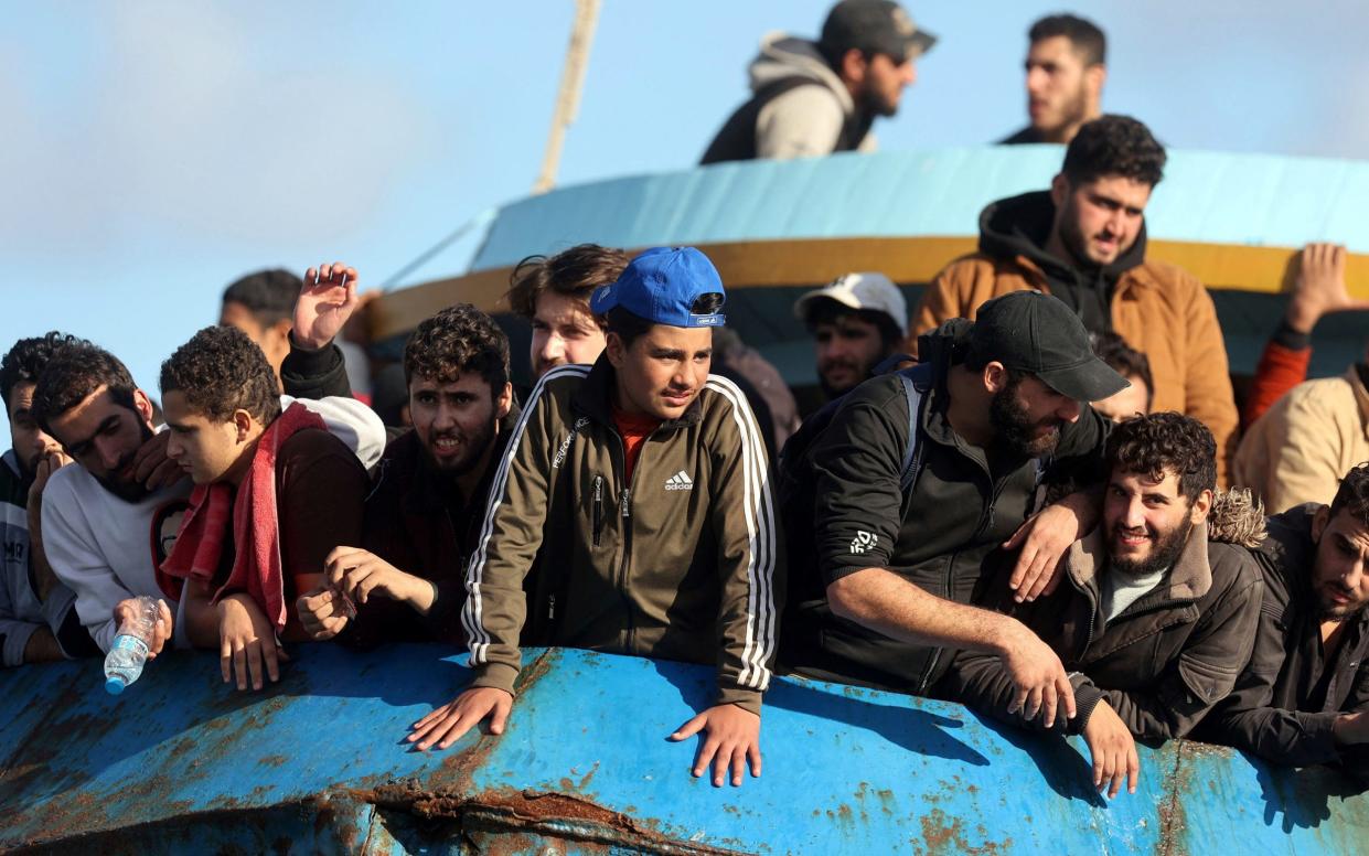 Rescued refugees and migrants stand aboard a boat at the town of Paleochora, Crete, following a rescue operation - Costas Metaxkis/AFP via Getty Images