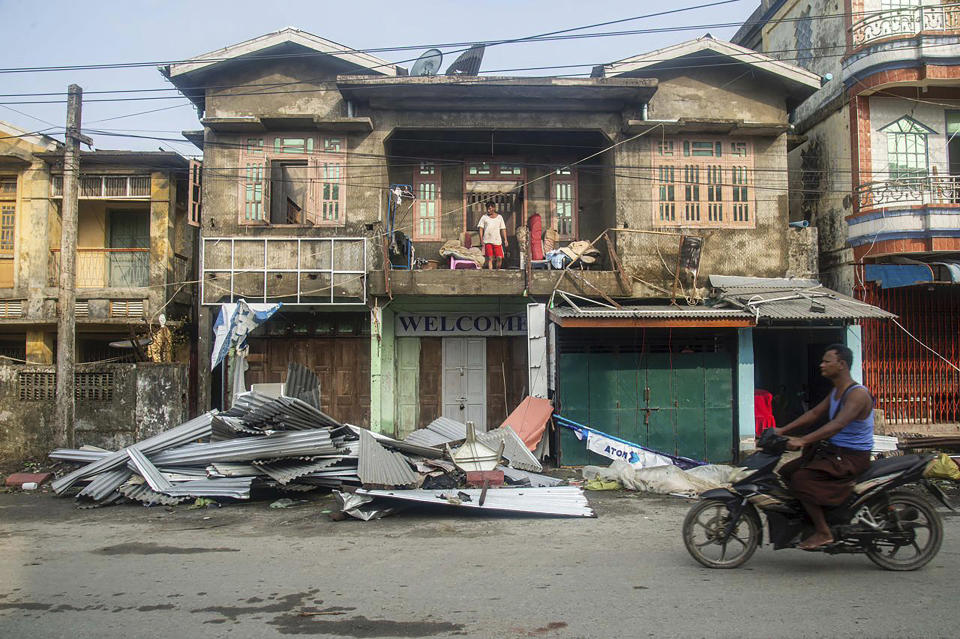 FILE- A local rides motorbike past damaged buildings after Cyclone Mocha in Sittwe township, Rakhine State, Myanmar, Monday, May 15, 2023. Early warnings from weather agencies and preparedness by local governments and aid agencies likely saved thousands of lives from a power Cyclone in that might have been claimed by the cyclone that slammed into the joint coastline of Bangladesh and Myanmar on Sunday. But there are concerns over the large number of people still unaccounted for in regions where preventative action was lacking. (AP Photo, File)