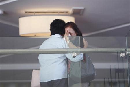 A relative (front) of a passenger of Malaysia Airlines flight MH370 cries as she walks past journalists at a hotel in Beijing March 9, 2014. REUTERS/Jason Lee