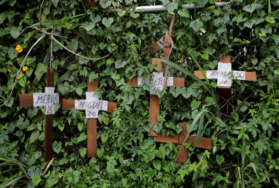 Cardboard crosses with the name of demonstrators killed during protests against the government are attached on a fence on July 20.