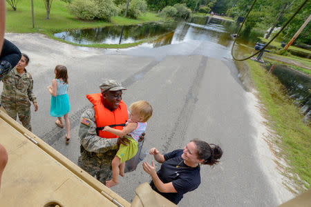 U.S. Army Pfc. Marlen Squire, of the South Carolina National Guard, assists in evacuating local residents from floodwaters as a result of Hurricane Florence in Dongola, South Carolina, U.S. September 24, 2018. Staff Sgt. Jorge Intriago/U.S. Army National Guard/Handout via REUTERS