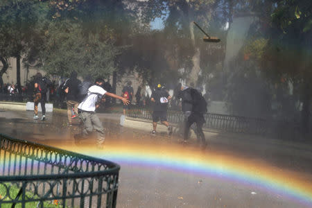 A demonstrator throws a broom toward riot police during a protest calling for changes in the education system in Santiago, Chile April 11, 2017. REUTERS/Ivan Alvarado